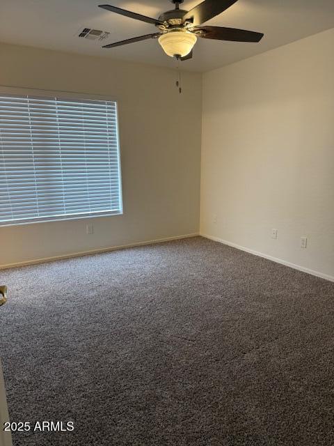 unfurnished room featuring carpet, ceiling fan, visible vents, and baseboards