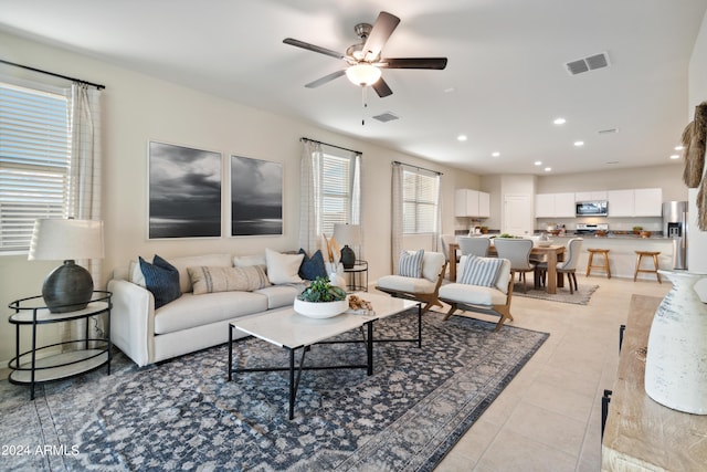 living room with ceiling fan, a wealth of natural light, and light tile patterned floors