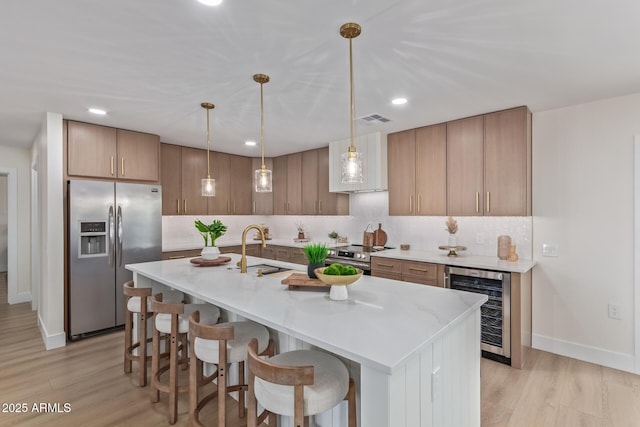 kitchen featuring wine cooler, tasteful backsplash, visible vents, appliances with stainless steel finishes, and a sink