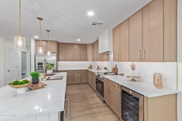 kitchen with wine cooler, stainless steel appliances, premium range hood, a sink, and visible vents