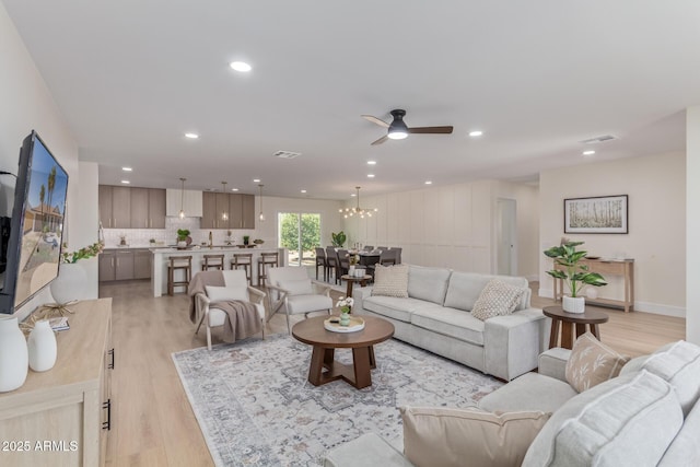 living area with light wood-type flooring, visible vents, and recessed lighting