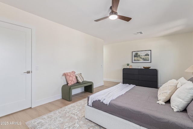 bedroom with a ceiling fan, wood finished floors, visible vents, and baseboards