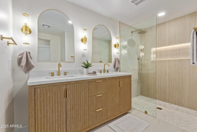 bathroom with a walk in shower, a sink, and visible vents