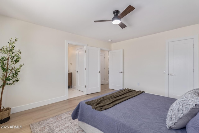 bedroom with ensuite bathroom, ceiling fan, baseboards, and wood finished floors