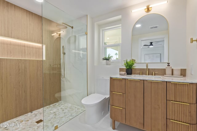 bathroom featuring toilet, visible vents, a walk in shower, and vanity