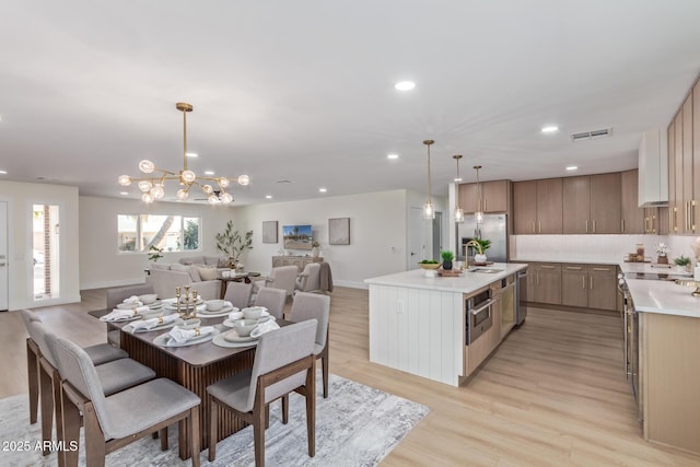 dining room with light wood finished floors, baseboards, visible vents, an inviting chandelier, and recessed lighting