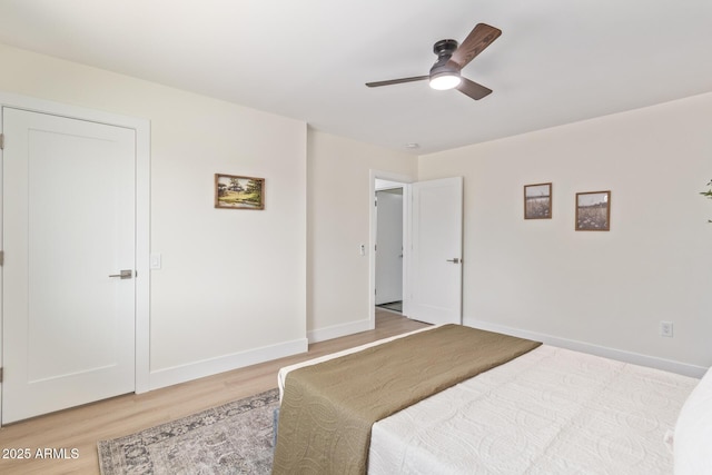 bedroom featuring light wood-style floors, baseboards, and a ceiling fan