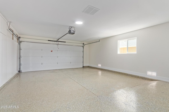 garage featuring baseboards, visible vents, and a garage door opener