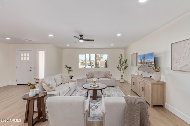 living area with light wood-style floors, baseboards, a ceiling fan, and recessed lighting