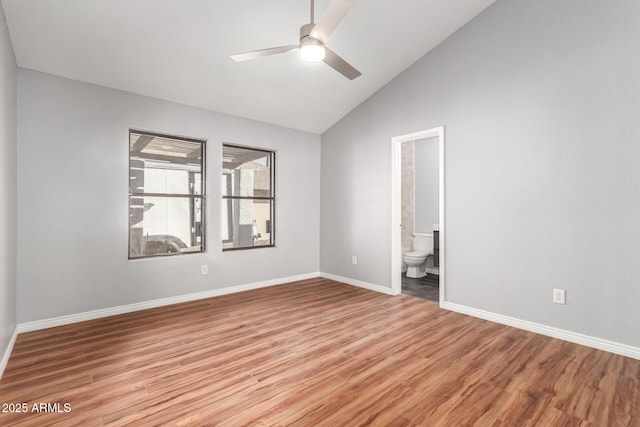 empty room with ceiling fan, light wood-type flooring, and vaulted ceiling