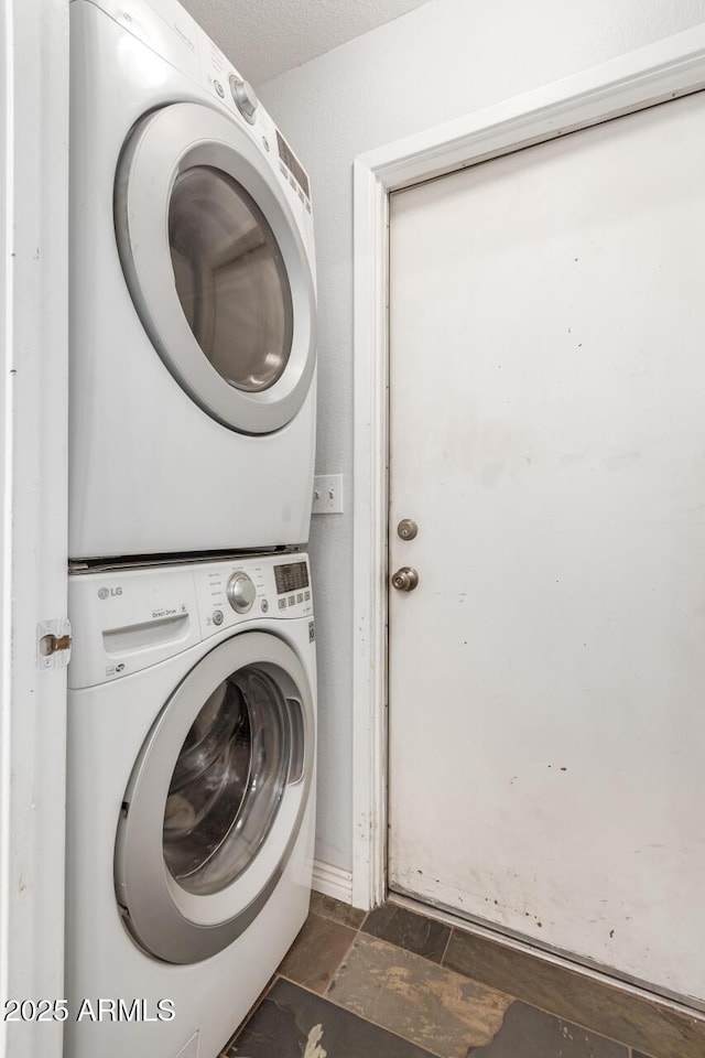 clothes washing area with stacked washer / dryer