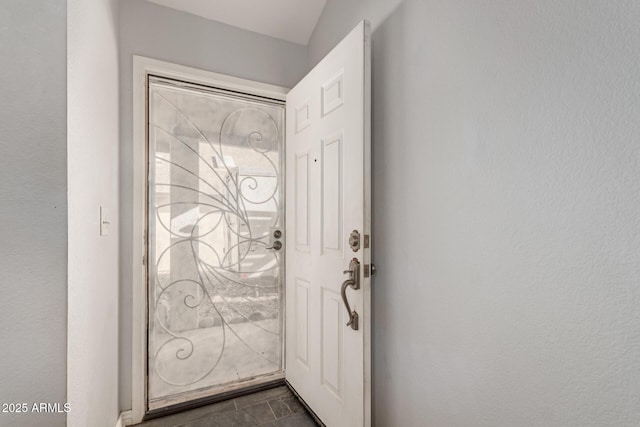 entryway with dark tile patterned floors