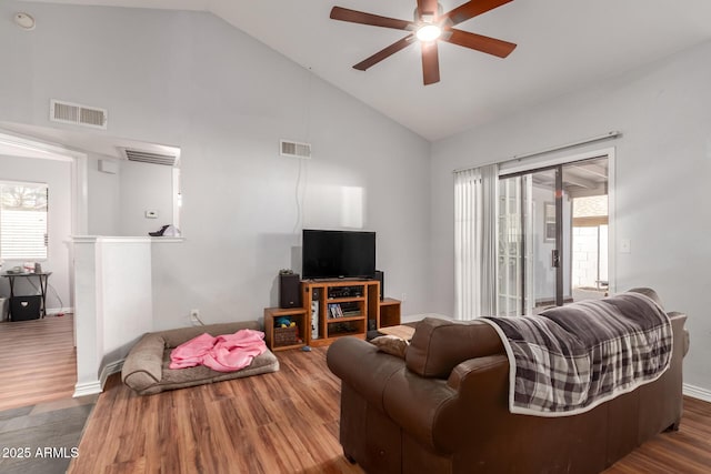 living room with a healthy amount of sunlight, high vaulted ceiling, ceiling fan, and dark wood-type flooring