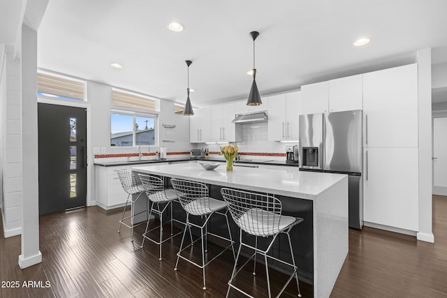 3402 E Sells Dr, Phoenix, AZ 85018 - kitchen featuring stainless steel refrigerator with ice dispenser, a kitchen island, a sink, a kitchen bar, and tasteful backsplash