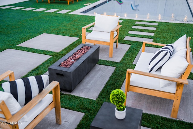 view of green lawn with a patio area and an outdoor living space with a fire pit