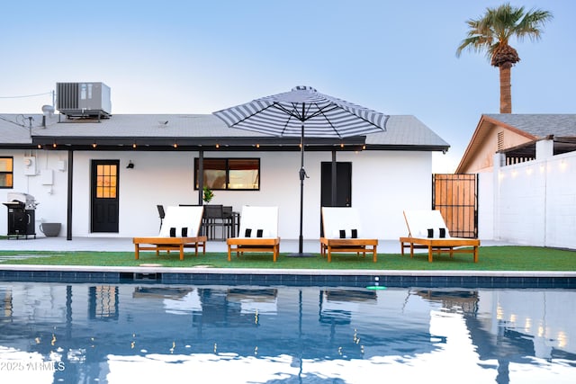 back of house featuring central AC unit, stucco siding, fence, and a patio