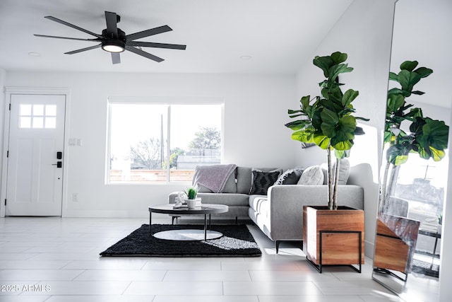 living area featuring a ceiling fan and baseboards