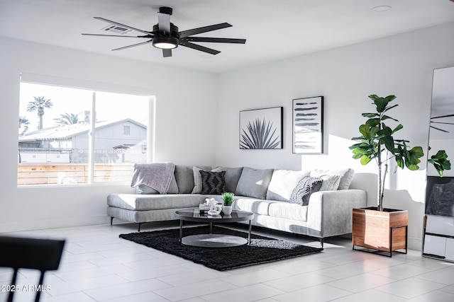 living area with healthy amount of natural light, ceiling fan, and baseboards