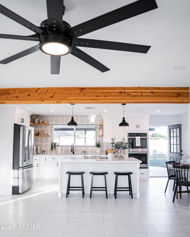 kitchen featuring stainless steel appliances, open shelves, a breakfast bar area, and tasteful backsplash