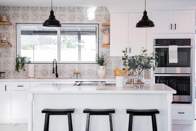 kitchen with stainless steel double oven, a breakfast bar, light countertops, and a sink