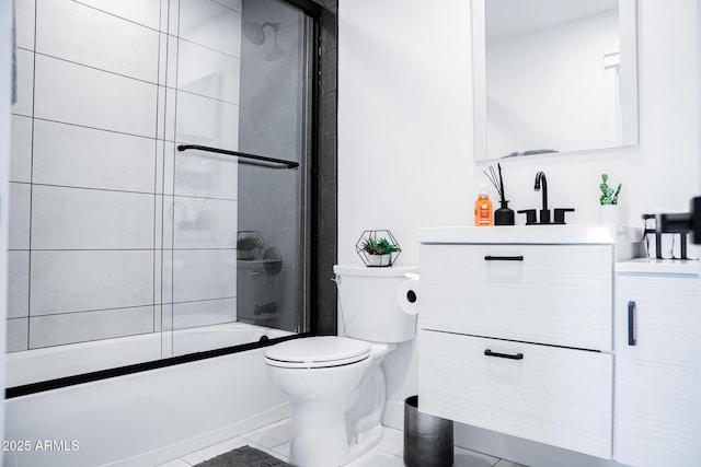 bathroom featuring toilet, vanity, combined bath / shower with glass door, and tile patterned flooring