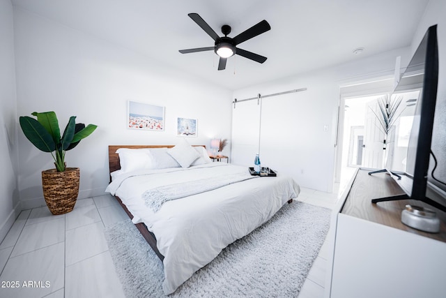 bedroom with a barn door and a ceiling fan