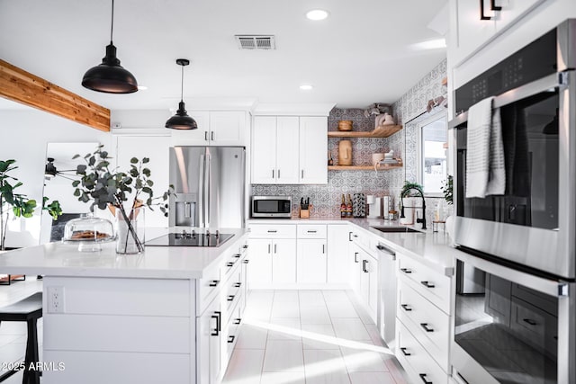 kitchen with a sink, stainless steel appliances, recessed lighting, light countertops, and tasteful backsplash