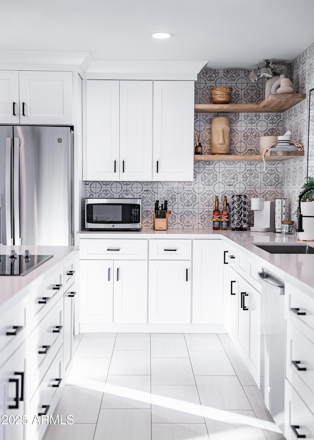 kitchen with appliances with stainless steel finishes, open shelves, light countertops, decorative backsplash, and recessed lighting