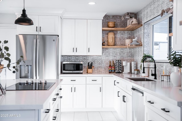 kitchen with stainless steel appliances, open shelves, a sink, decorative backsplash, and light countertops