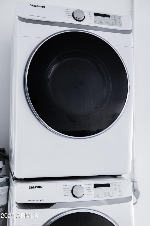 clothes washing area featuring estacked washer and dryer