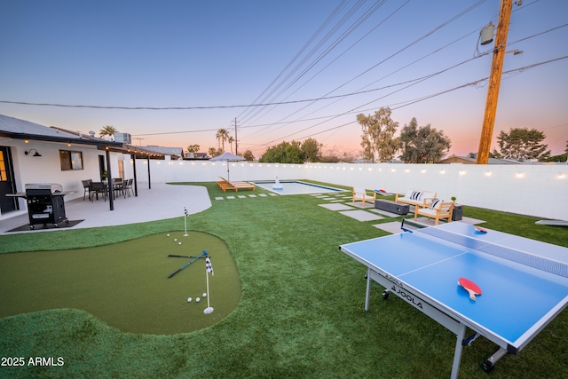 view of yard with an area to practice putting and a patio