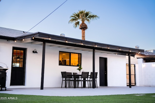 back of house featuring stucco siding and a patio