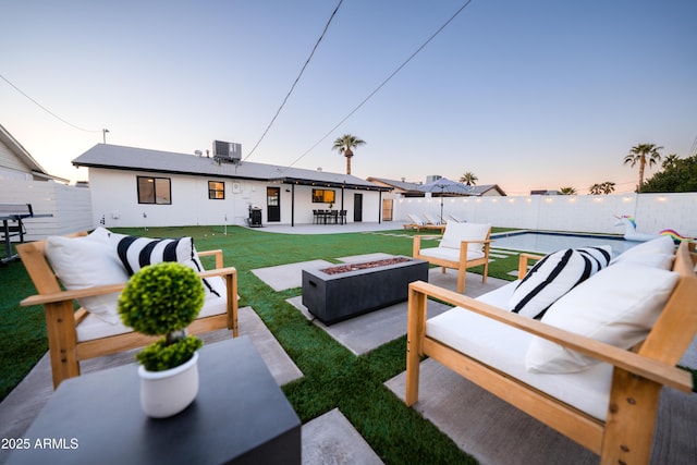 back of house at dusk with an outdoor living space with a fire pit, a patio area, and cooling unit