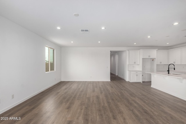 unfurnished living room with dark hardwood / wood-style floors and sink