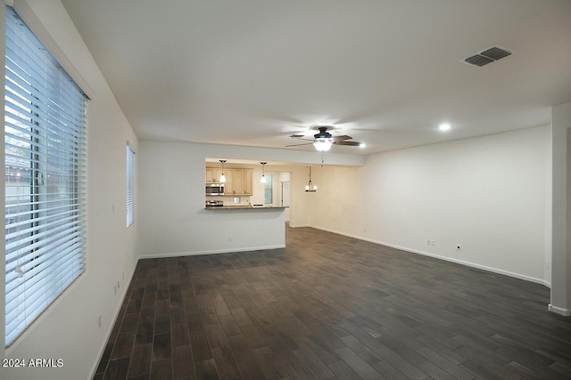 unfurnished living room with ceiling fan and dark wood-type flooring