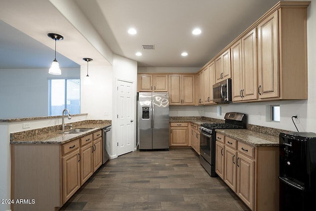 kitchen with sink, stainless steel appliances, dark wood-type flooring, dark stone countertops, and pendant lighting