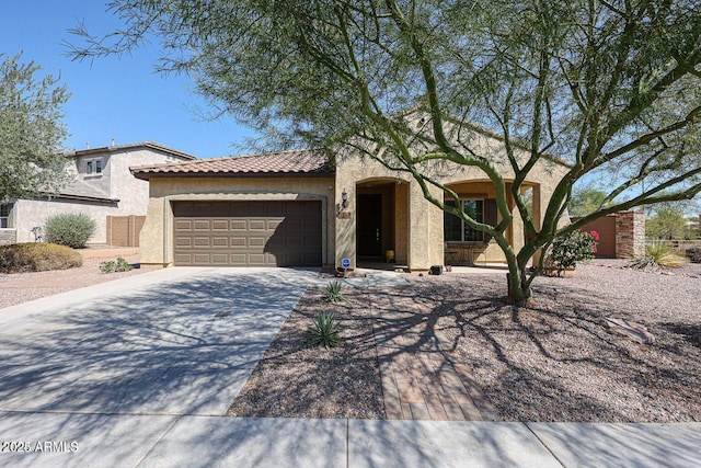 view of front of house with a garage, a tiled roof, concrete driveway, and stucco siding