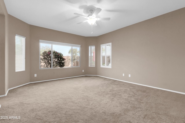 spare room featuring carpet flooring, ceiling fan, and baseboards