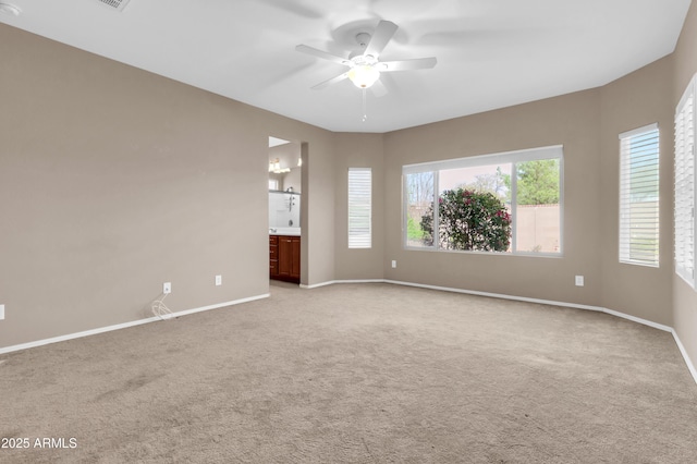 empty room featuring light carpet, baseboards, and a ceiling fan