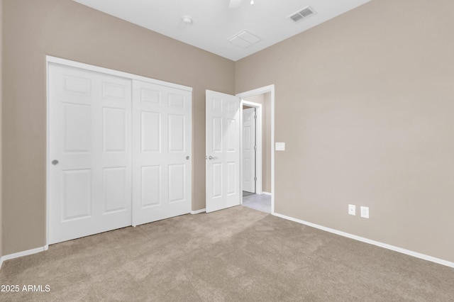 unfurnished bedroom featuring carpet floors, a closet, visible vents, and baseboards