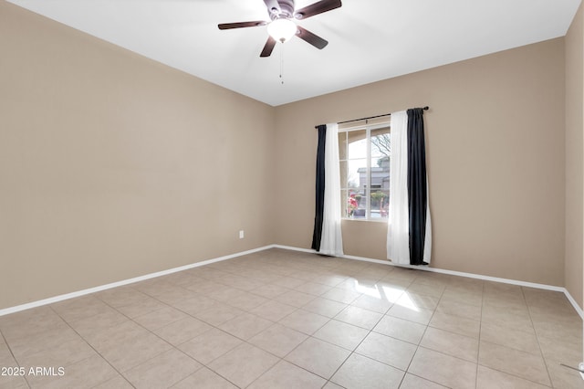 spare room featuring light tile patterned floors, ceiling fan, and baseboards