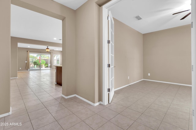 corridor with visible vents, baseboards, and light tile patterned floors