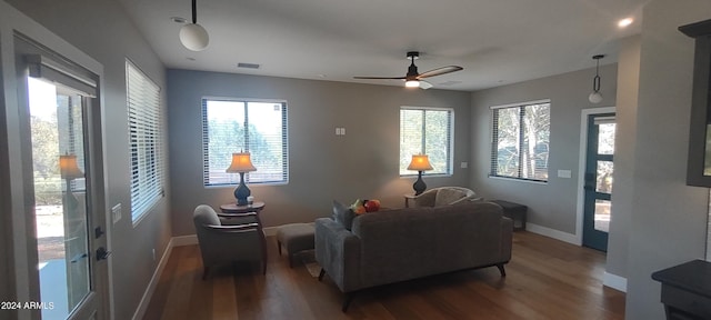 living room with dark hardwood / wood-style floors, ceiling fan, and a healthy amount of sunlight