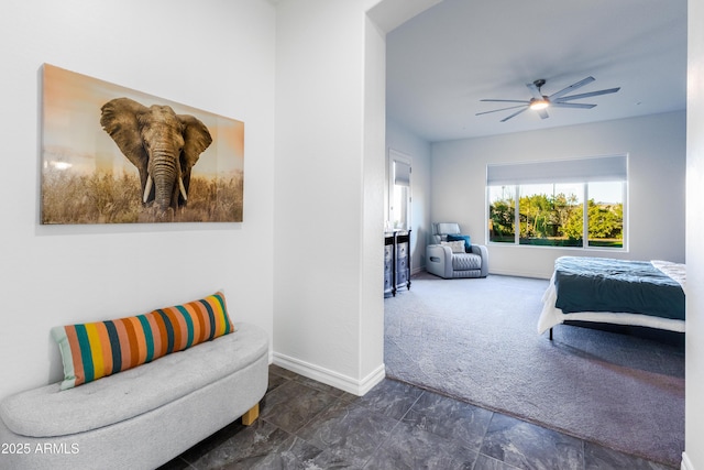 bedroom featuring ceiling fan, dark carpet, and baseboards