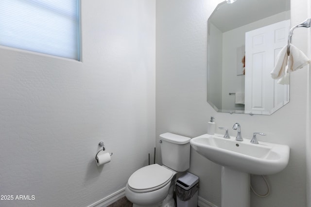 bathroom featuring toilet and baseboards