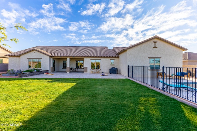 back of property featuring a yard, a patio, a fenced in pool, and stucco siding