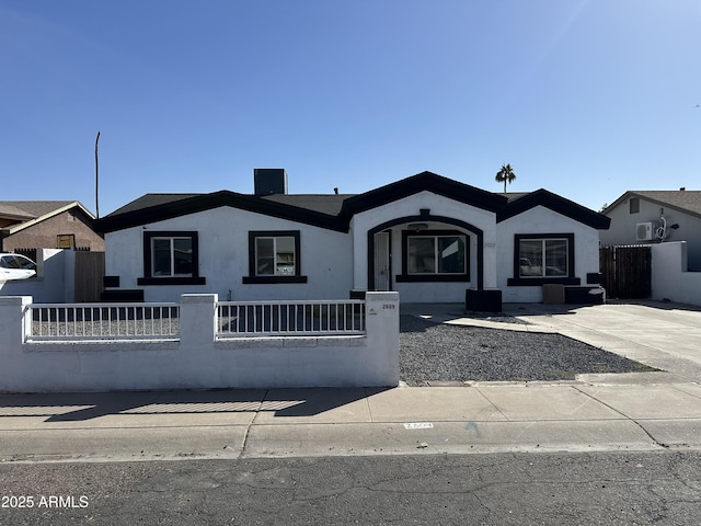 ranch-style house with a fenced front yard and stucco siding