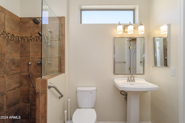 bathroom featuring toilet and tiled shower