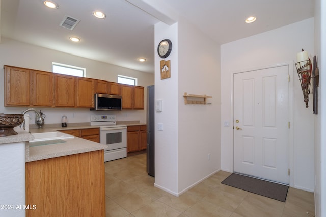 kitchen with sink, light tile floors, and stainless steel appliances