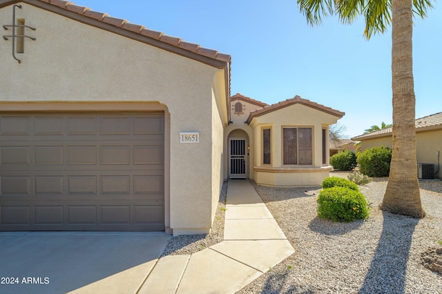 mediterranean / spanish house featuring central AC unit and a garage